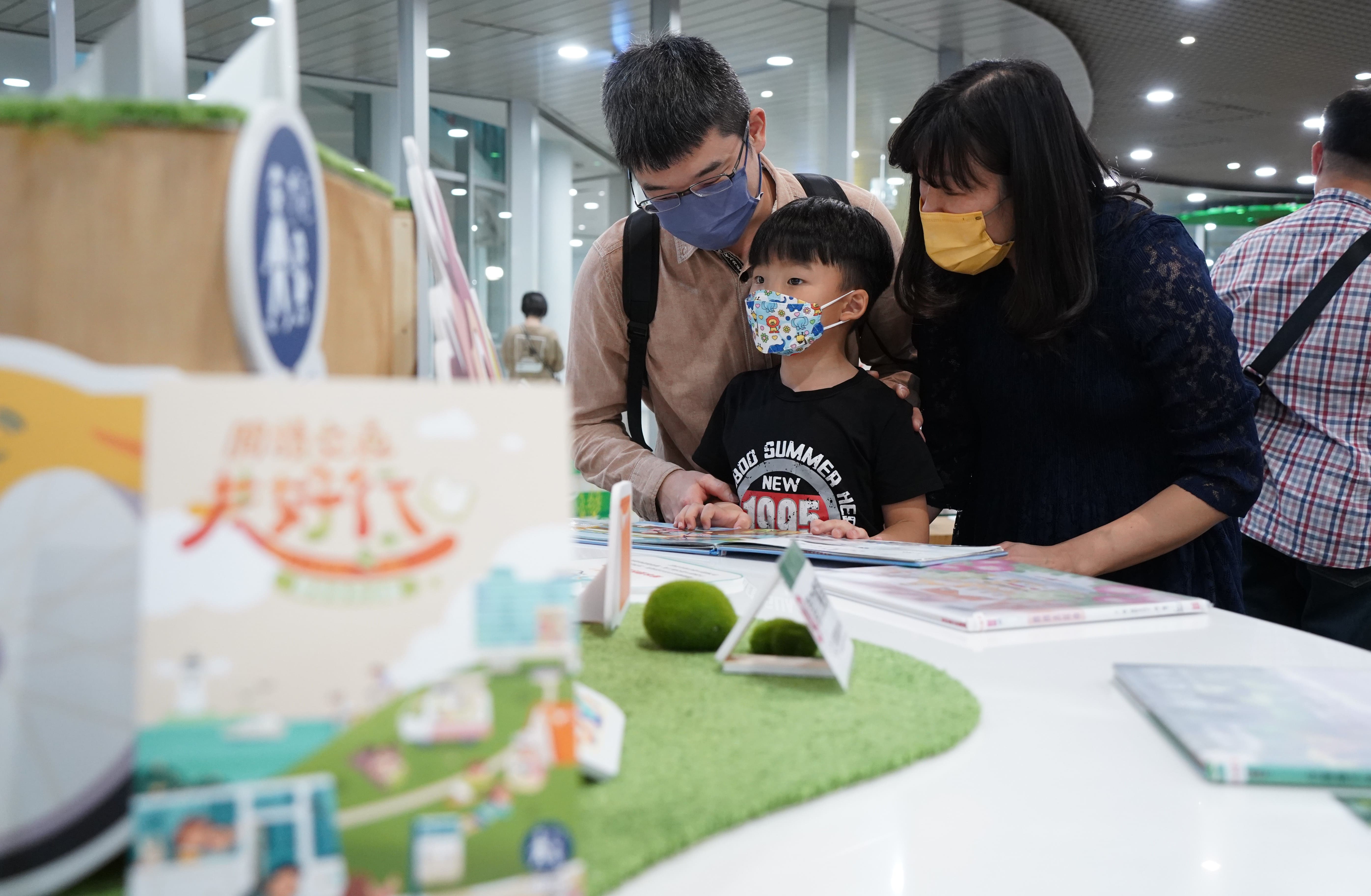孩子在書展特色專區「繪本裡的沿途風景」，閱讀《123轉台灣》。